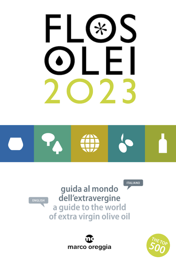 Portada de la guia "Flos Olei 2023", amb el títol principal i símbols de productes relacionats amb l'oli d'oliva verge extra, seguit del text en italià i anglès "guida al mondo dell'extravergine / a guide to the world of extra virgin olive oil".